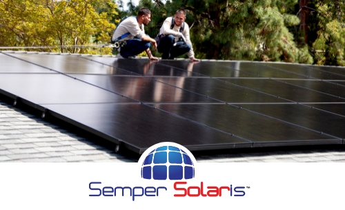 Two solar installers inspecting rooftop solar panels.