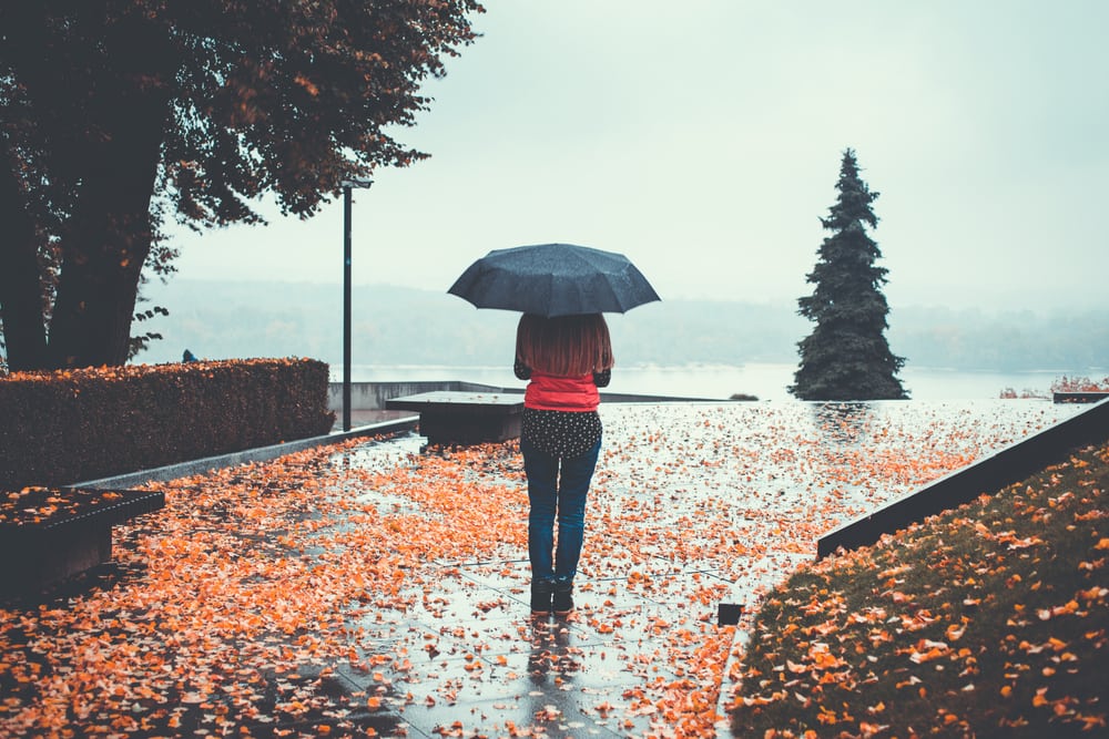 Woman standing under an umbrella on a rainy day