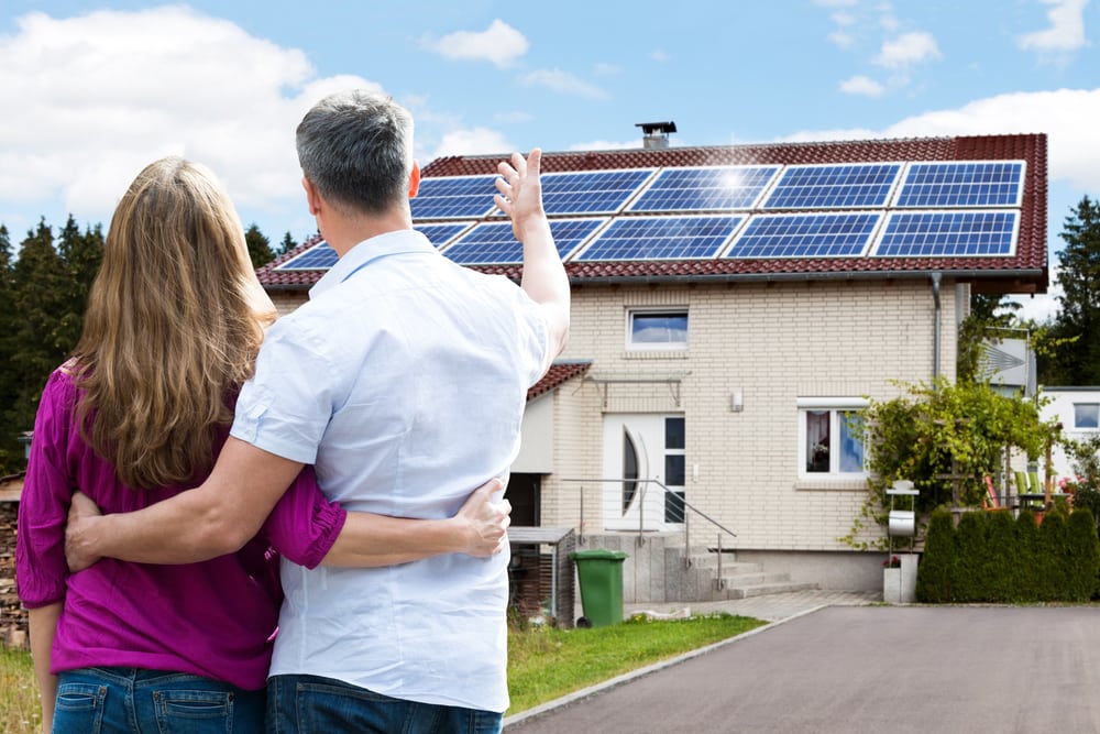 Happy couple enjoying solar panels on their home