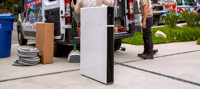 Tesla Powerwall being readied for home installation in front of a Semper Solaris truck.
