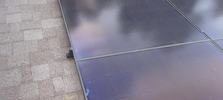 Close up of solar panels on shingle roof.
