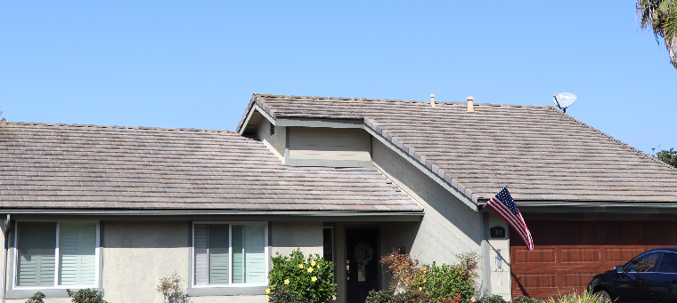 Крыша дома на одну семью с американским флагом на крыльце.