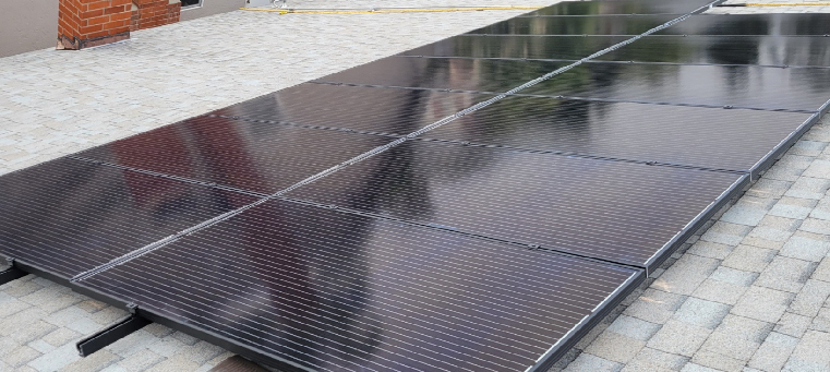 Thirteen solar panels on light asphalt-shingle roof with chimney.