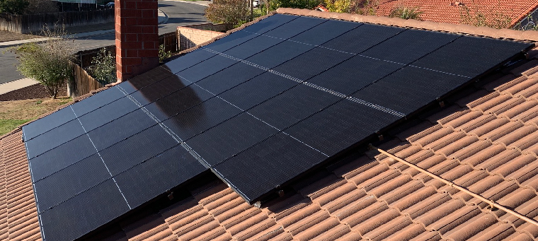 Seventeen solar panels on clay tile roof chimney.
