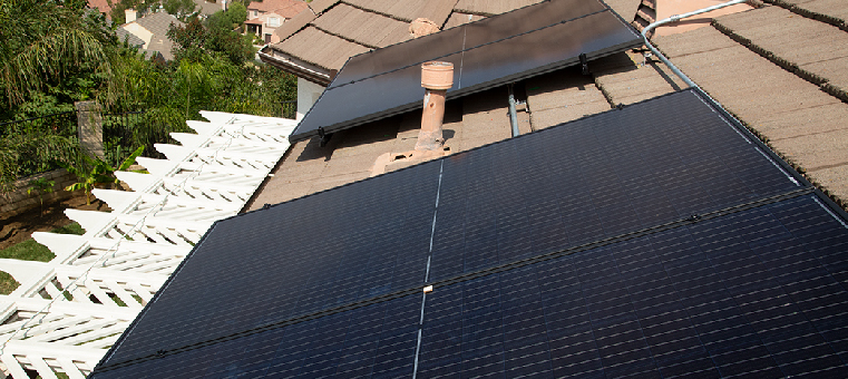 Solar panels on single family home with white pergola.