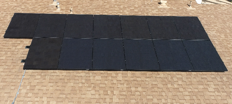 Thirteen solar panels on asphalt shingle roof of single story home.