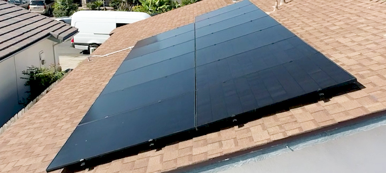 Thirteen solar panels on asphalt shingle roof of single story home van.