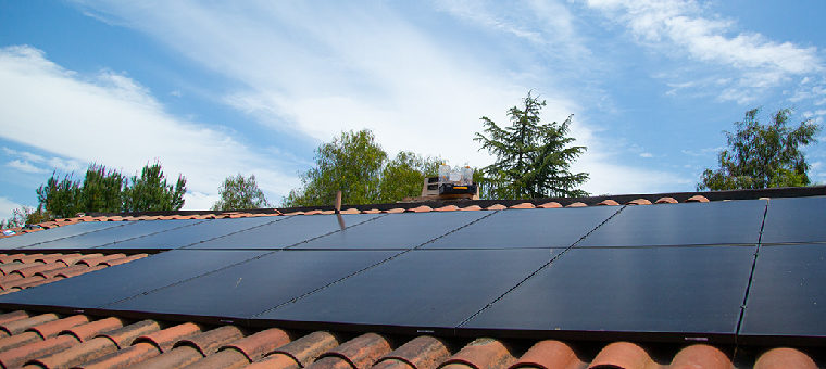 Solar panels on clay tile roof of single family home.