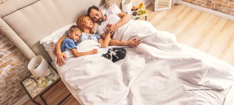 Family laying in bed comfortably after their heating and air conditioning system was installed in Menifee.