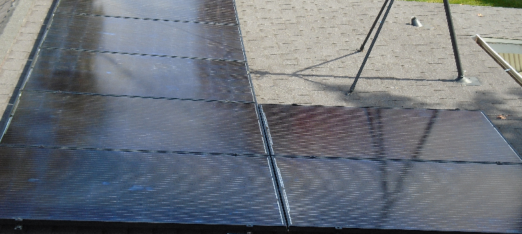 Seven solar panels on asphalt-shingle roof of single-family home.