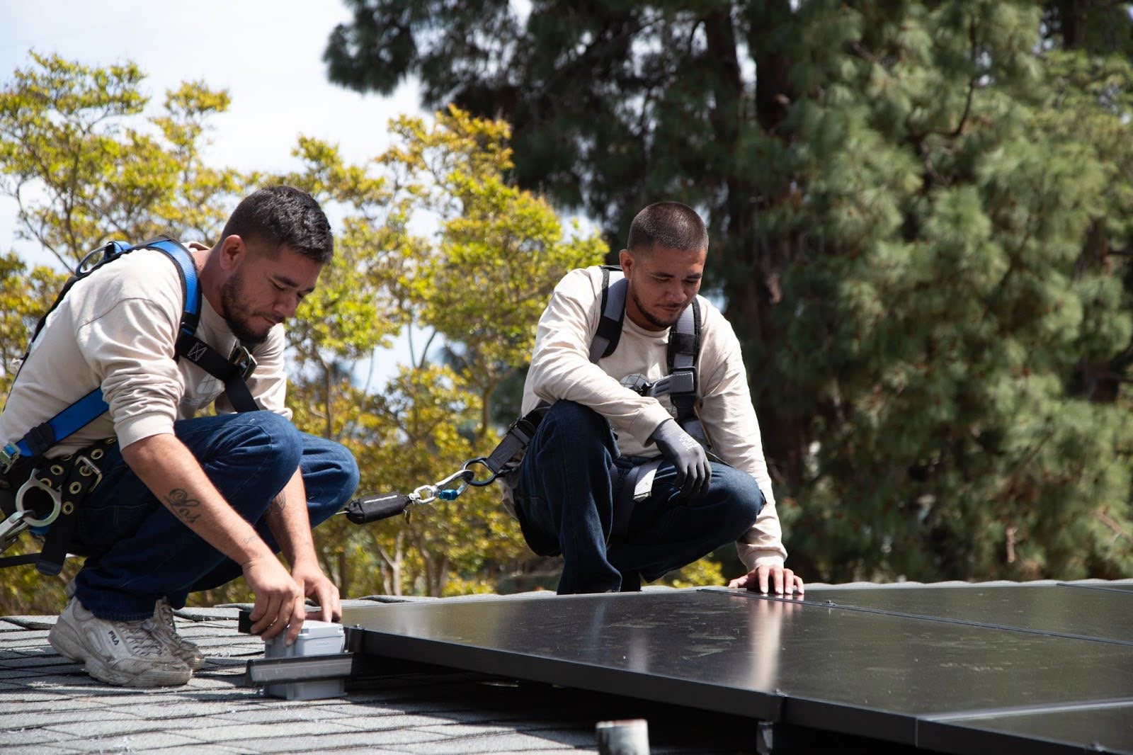 Two Semper Solaris technicians installing solar panels on a house in California. 