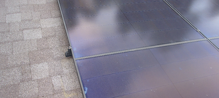 Close up of solar panels on shingle roof.