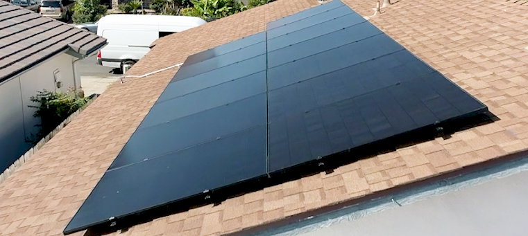 Thirteen solar panels on asphalt shingle roof of single story home van.